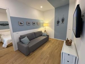 a living room with a couch and a flat screen tv at Sidera Cinque Terre Apartments in Biassa