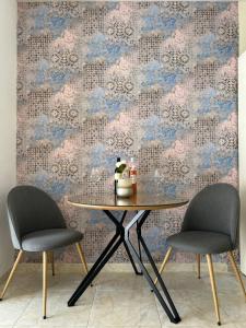 a table and two chairs in a room with a wallpaper at Villa Marie in Baška Voda