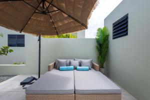 een patio met een tafel en een parasol bij Villa Kura Cura - 5 Minutes From Mambo Beach in Willemstad +26 foto's