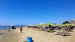 a crowd of people on a beach with umbrellas at Vila Green Relax in Vlorë