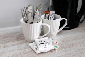 two white cups with utensils and a sign that says happy birthday at El Guest Lodge & Spa in East London