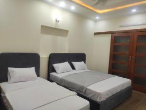 a bedroom with two beds and a wooden cabinet at Serenity Cottage in Islamabad +30 photos