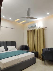 a bedroom with a bed and a ceiling fan at Serenity Cottage in Islamabad
