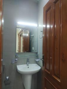 a bathroom with a sink and a mirror at Serenity Cottage in Islamabad