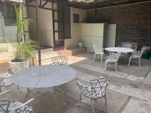 a patio with two tables and chairs and tables and chairs at Hotel Tonalà in Tonalá