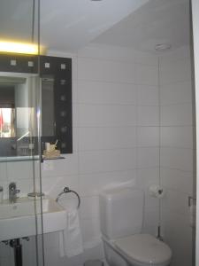 a white bathroom with a toilet and a sink at Gasthof Löwen in Bubikon +24 photos