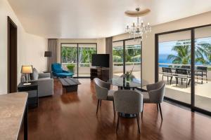 a living room with a dining table and a view of the ocean at Le Meridien Phuket Beach Resort in Karon Beach