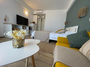 una sala de estar con dos camas y un sofá en ROCA Seaview Apartments, en 23 August