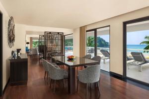 a dining room with a table and chairs and the ocean at Le Meridien Phuket Beach Resort in Karon Beach