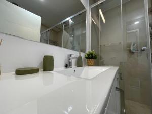 Un baño blanco con lavabo y ducha. en ROCA Seaview Apartments, en 23 August 11 fotos más