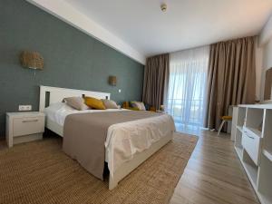 Un dormitorio con una cama grande y una ventana grande. en ROCA Seaview Apartments, en 23 August