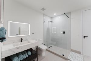 a white bathroom with a shower and a toilet at Modern 2BR Apt Near Hard Rock with Parking & Gym in Fort Lauderdale