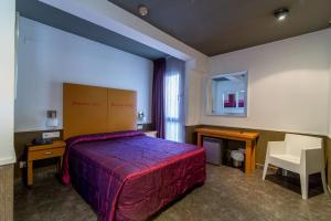 a bedroom with a bed and a desk and a chair at Colors in Barcelona