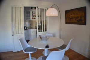 a dining room with a white table and chairs at L'Invitation au Voyage in Bordeaux