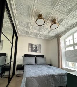 a bedroom with a bed with a coffered ceiling at Elegant Three-Bedroom Apartment with Stunning Sea Views - Limited availability - Secure your booking for Christmas 2025 and Summer 2026 in Ålesund