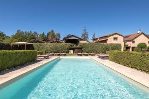 a swimming pool with benches in a yard at Domaine des Ormeaux in Ajat