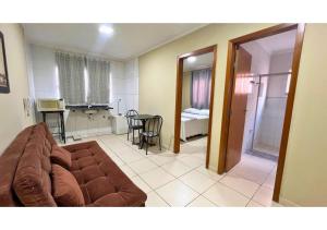 a living room with a couch and a dining room at Flat Bueno Inn in Goiânia