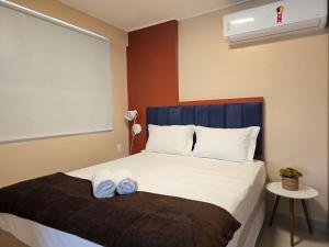 a bedroom with a bed with two towels on it at Apê Ótima Localização, Cozinha, Coworking, Fitness in Maceió +29 photos