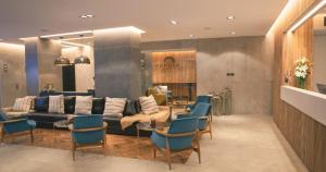 a living room with a couch and blue chairs at Park Royal City Buenos Aires in Buenos Aires +20 photos