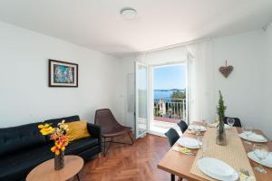 a living room with a couch and a table with flowers at Vila Azur in Mlini