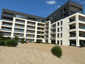 an apartment building with a beach in front of it at Horizon Park 33 Boszkowo in Boszkowo