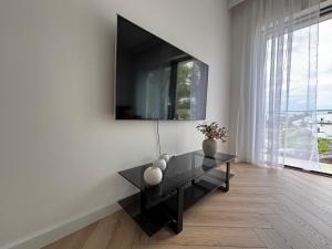 a living room with a black table and a tv on a wall at Horizon Park 33 Boszkowo in Boszkowo