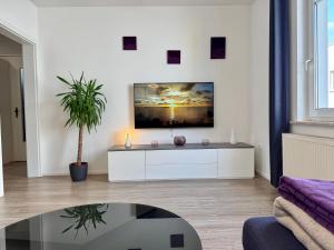 a living room with a tv on a wall at Im Herzen von Bad Mergentheim in Bad Mergentheim