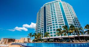 a tall building with a swimming pool in front of it at Park Royal Mazatlán in Mazatlán