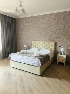 a bedroom with a large bed and two night stands at Nicola House in Borjomi in Borjomi +5 photos