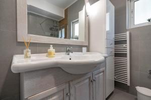 a bathroom with a white sink and a mirror at G&A Family Home near the Beach by MΡS in Nea Makri +43 photos