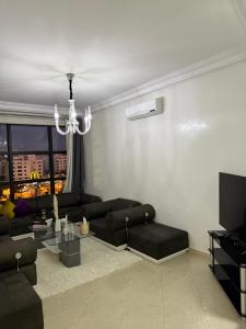 a living room with a couch and a chandelier at Une pépite avec vue panoramique playa, Tanger in Oulad Akkou
