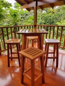 a wooden table and two stools on a porch at MAYU PATANPI Amazon Lodges in Tarapoto