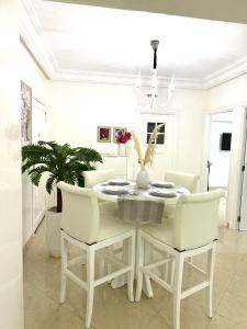a white dining room with a white table and chairs at Une pépite avec vue panoramique playa, Tanger in Oulad Akkou