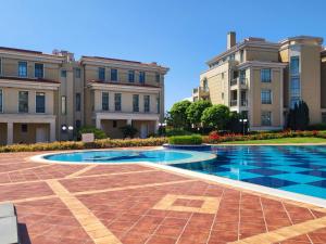 a courtyard with a swimming pool in front of two buildings at Solea Studio in Chernomorets