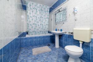 a blue tiled bathroom with a toilet and a sink at Apartments and rooms Bionda in Senj +127 photos