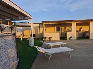 a patio with a table and a bench and a building at Case Victoria - Mamalu in Lampedusa