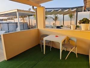 a small white table and chairs on a balcony at Case Victoria - Mamalu in Lampedusa
