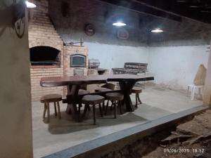 a table and chairs in a room with a brick oven at Sítio do patinhas in Nova Iguaçu