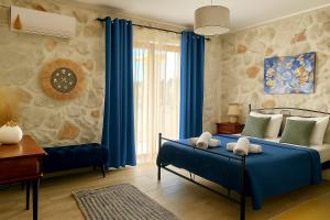 Schlafzimmer mit blauem Bett und blauen Vorhängen in der Unterkunft La Casa Del Sole in Agios Leon