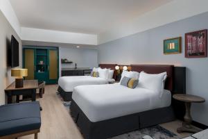 韦斯特切斯特Hotel Indigo West Chester - Downtown by IHG的有两张床和一张桌子的酒店房间