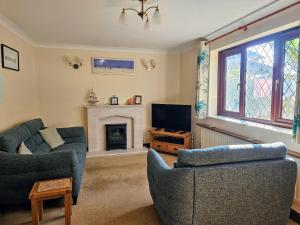 a living room with two couches and a fireplace at Chiffchaff in Padstow
