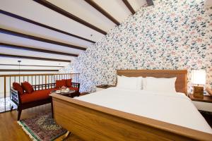 ein Schlafzimmer mit einem Bett und einer Wand mit Blumen in der Unterkunft The Sultan in Singapur