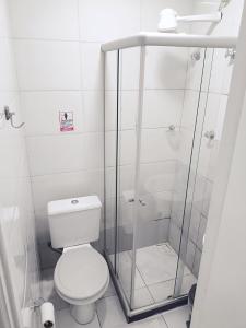 a white bathroom with a toilet and a shower at Solar Hostel Centro in Rio de Janeiro