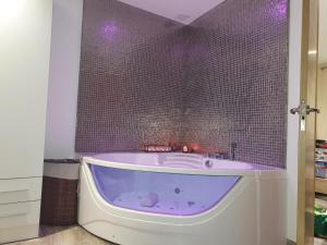 eine lila Badewanne in einem Badezimmer mit gefliester Wand in der Unterkunft Casa pepa in Marbella