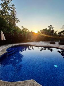a swimming pool with the sunset in the background at Villa Montana in Tarcoles