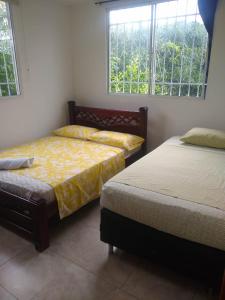 Casa Hotel Marly في سانتا مارتا: غرفة نوم بسريرين ونوافذ