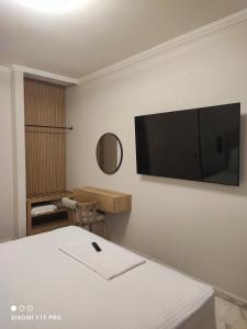 a room with a bed and a flat screen tv on the wall at Niriton Pension in Nydri