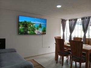 a living room with a table and a tv on the wall at Casa Hotel Pontevedra - cerca a la clínica Shaio, in Bogotá