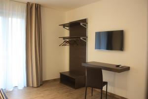 um quarto com uma secretária e uma televisão de ecrã plano em Terrazzi in Fiore em Alghero