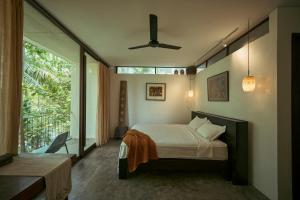 a bedroom with a bed and a large window at Kyara Arthouse Villa in Thanh Ðông (1)